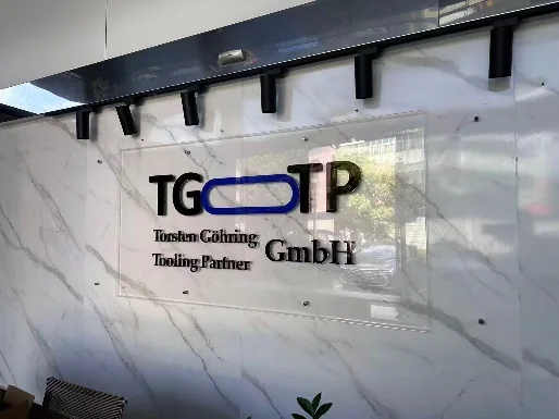 Acrylglas-Schild der TG-TP GmbH an der Marmorwand des Empfangs